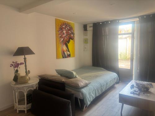 a bedroom with a bed and a table with a lamp at Petite halte à Volnay in Volnay