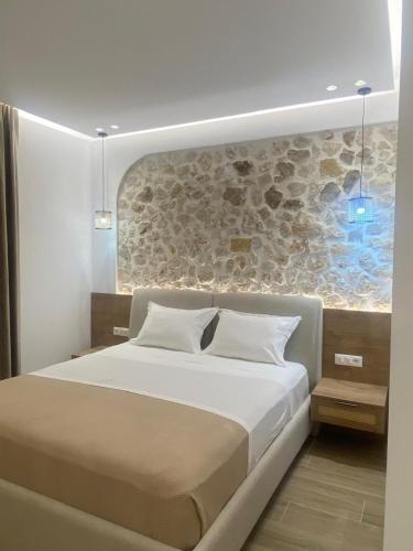 a bedroom with a large bed with a stone wall at Villa Xani in Himare