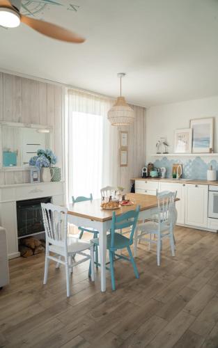 a kitchen with a dining room table and chairs at Coco Beach Cupel - Domek AQUA z jakuzzi in Cupel