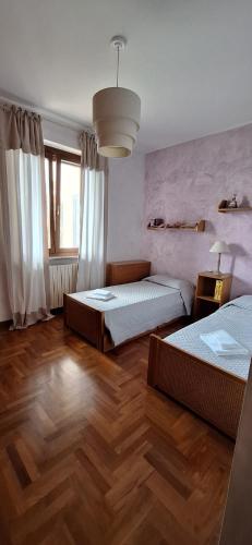 a bedroom with two beds and a large window at Roby53 in Parabiago