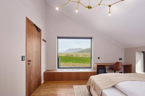a bedroom with a bed and a large window at Tindasel - The Farm in Hella