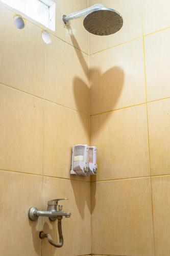 a bathroom stall with a water dispenser on a wall at Al Barra Syariah Hotel in Bukittinggi