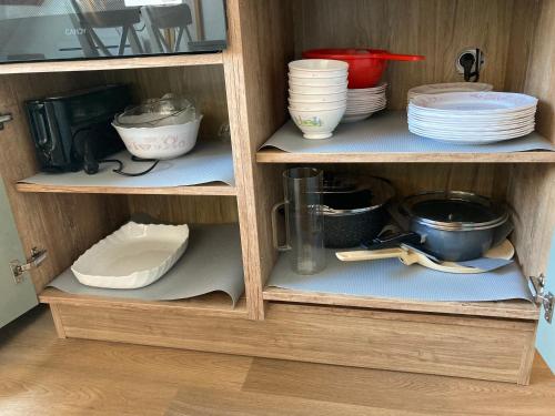a cupboard with dishes and plates in it at 2 chambres avec mezzanine in Le Lioran