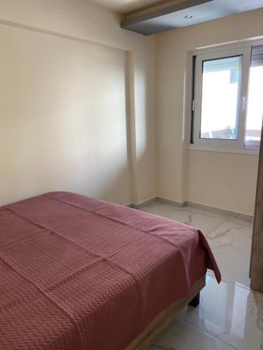 a bedroom with a bed and a window at Apartman Velickovic in Paralia Katerinis
