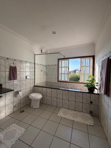 a bathroom with a toilet and a window at Hostel onda azul in Serra
