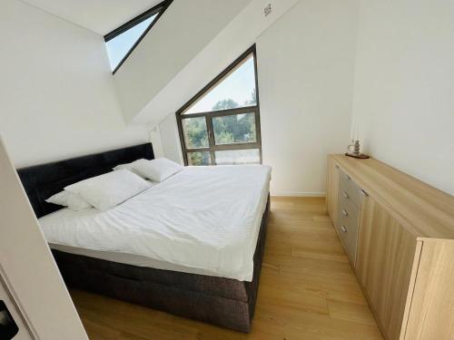 a bedroom with a bed and a large window at V7 Apartamentai Nidoje in Nida