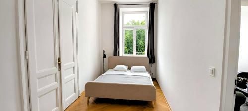 a small bedroom with a bed and a window at Apartament na Granicy 5 in Cieszyn