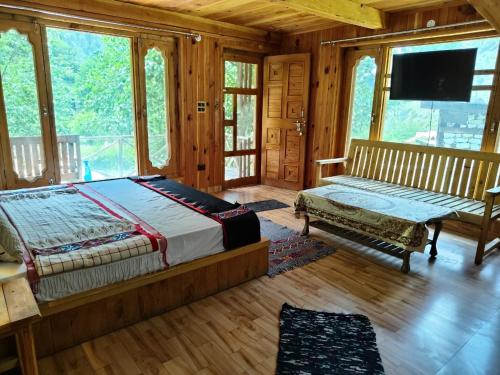 ein Schlafzimmer mit Bett, Fernseher und Fenstern in der Unterkunft Him cottage in Gushaini