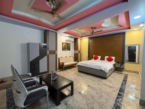 a bedroom with a bed and a desk and a chair at Hotel Nalanda City in Nalanda