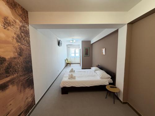 ein Schlafzimmer mit einem Bett und einem Gemälde an der Wand in der Unterkunft Hotel Storia in Čapljina