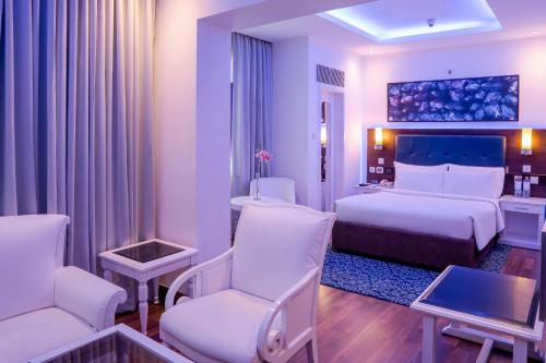 a hotel room with a bed and two chairs at Radisson Blu Kochi in Cochin