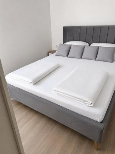 a large bed with white sheets and pillows on it at Sofija 1 in Jesenice