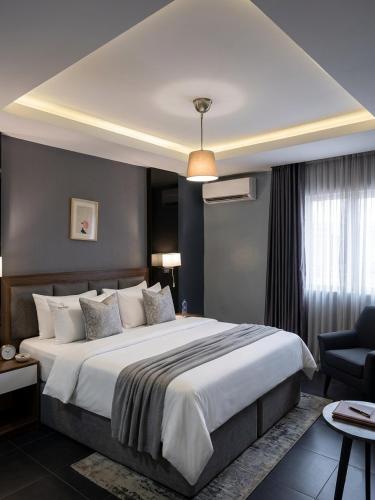 a bedroom with a large bed and a chair at Edge ONE Resort in Gwarinpa