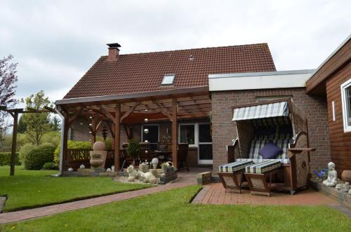 a house with a gazebo in the yard at Ferienhaus Nikki 35528 in Uplengen