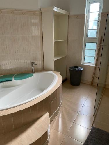 a large bathroom with a tub and a window at Bord Mer House in Glacis