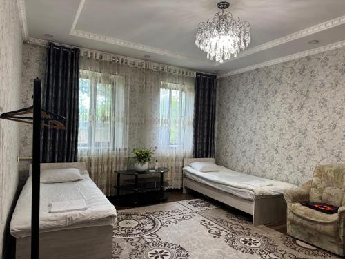 a bedroom with two beds and a chandelier at Shabdan Guest House in Toktogul