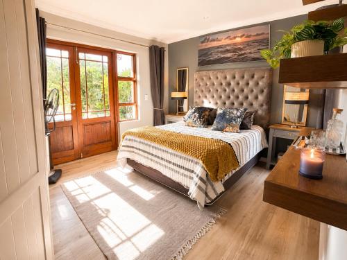 a bedroom with a large bed and a window at Captains Quarters in Plettenberg Bay