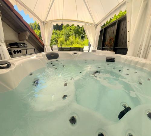 a large jacuzzi tub in a white tent at Suite Verte Vallée Meisenthal spa privatif in Meisenthal