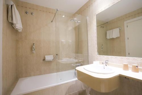 a bathroom with a sink and a shower with a mirror at Hotel Oasis in Córdoba