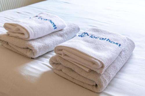 a pile of towels sitting on top of a bed at Gaia - 4 Bedroom House in Larnaca in Larnaca