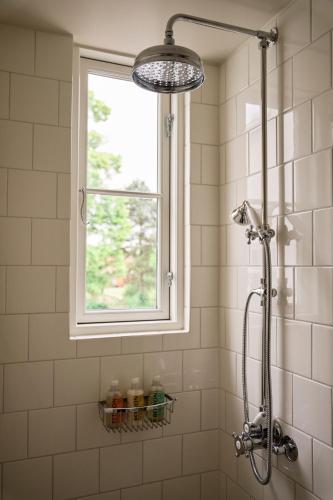 a shower in a bathroom with a window at Josty Frederiksberg in Copenhagen