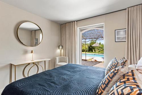 a bedroom with a bed and a view of a pool at Villa Seize St Tropez in Saint-Tropez