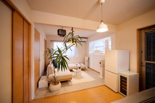 a living room with a refrigerator and plants in it at Shiki Art Hotel Yufu in Yufu