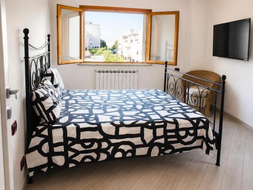 a bedroom with a bed with a black frame and a window at La Casa al Mare in Pescara