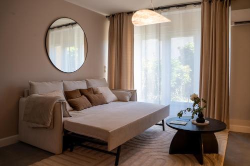 a living room with a couch and a mirror at 1 Peraudel Suite & Appartements in Castres