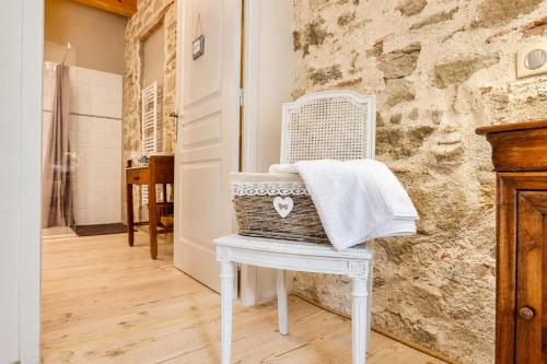 a white chair with a towel on it in a bathroom at Domaine de la Salutière - Charme & Confort au cœur du Pays Cathare in Lauraguel