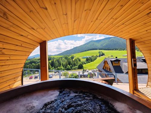 an outdoor hot tub with a view of the mountains at Salaš Syrex in Zázrivá