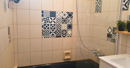 a bathroom with a shower with blue and white tiles at Minavita - Vue mer, Plage à pied, Ruppione, Corse in Pietrosella