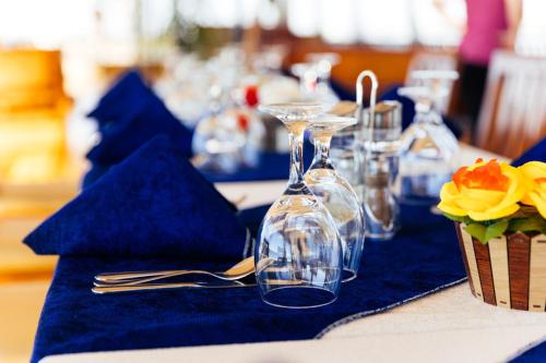 a table with blue napkins and glasses and a vase at Dahabiya Queen Tyi II in Luxor