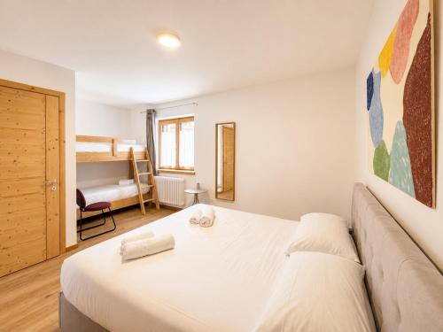 a bedroom with a white bed and a couch at Blu Betulle, Free Park and Ski room in Camporosso in Valcanale