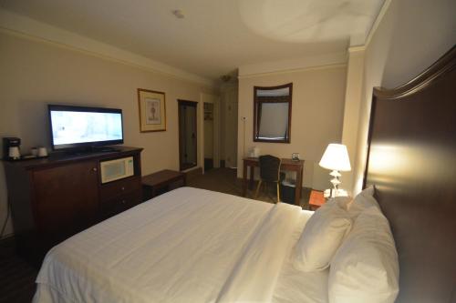 a hotel room with a bed and a flat screen tv at Prince Arthur Waterfront Hotel & Suites in Thunder Bay