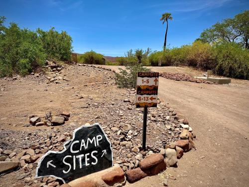 a sign on the side of a dirt road at Palmwag Campsite in Palm