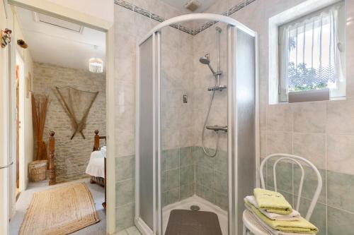 a shower with a glass door in a bathroom at Chambres D'hôtes Le Peux in Saint-Pierre-le-Vieux