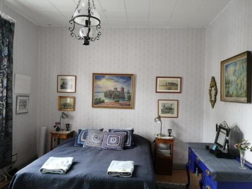 a bedroom with a blue bed and a chandelier at Foggy Island B&B in Kaskö
