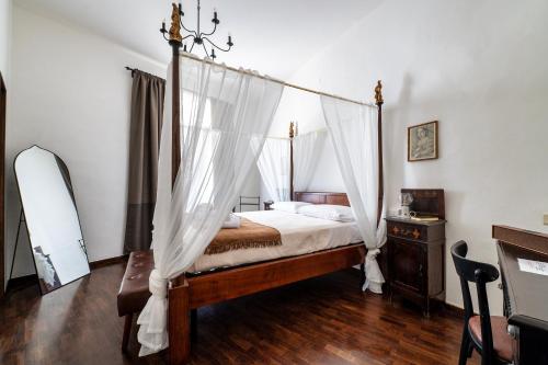 a bedroom with a canopy bed with mosquito nets at La Dama Stanca in Narni