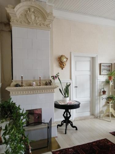 a living room with a fireplace and a table at Foggy Island B&B in Kaskö