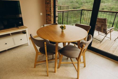 a wooden table and chairs in a room with a balcony at Casa Monti in Ijevan