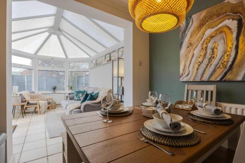 a dining room with a table with plates and wine glasses at 3-Bed Retreat Perfect Contractors & Leisure Stays Onsite Parking in Messingham