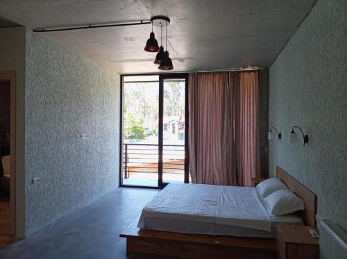 a bedroom with a bed and a large window at IO House in Urekis Sadguri
