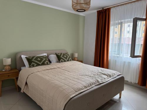 a bedroom with a bed and a large window at Cazare Târgu Secuiesc in Târgu Secuiesc