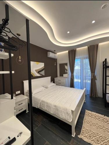 a bedroom with a large white bed and a mirror at Villa Mucenji in Përmet