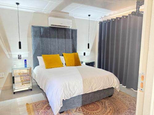 a bedroom with a large bed with two yellow pillows at Springbok Guest Farm in Springbok