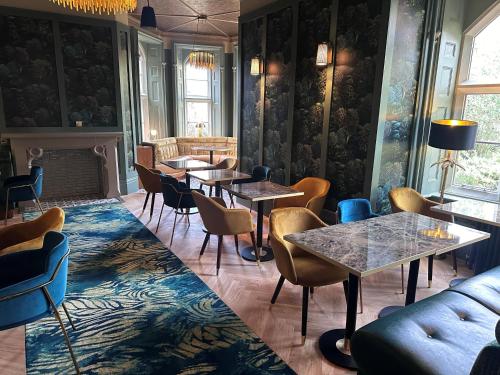 a restaurant with tables and chairs and a fireplace at Best Western Abbots Barton Hotel in Canterbury