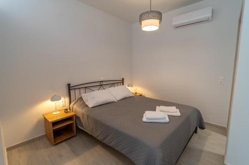 a bedroom with a bed with two towels on it at Studios Kerasioti in Pefki