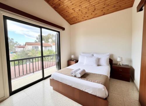 a bedroom with a bed and a large window at STAY Sea Gem Townhouse in Meneou