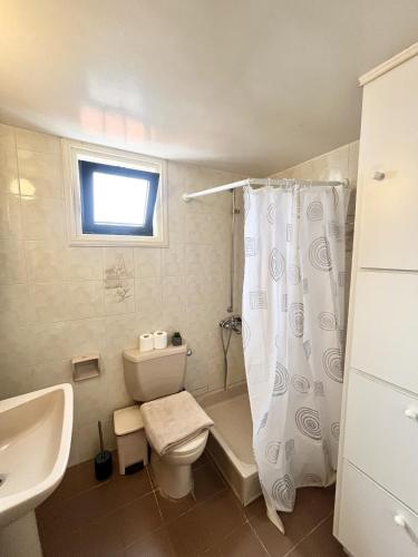 a bathroom with a toilet and a sink and a shower at STAY Sea Gem Townhouse in Meneou